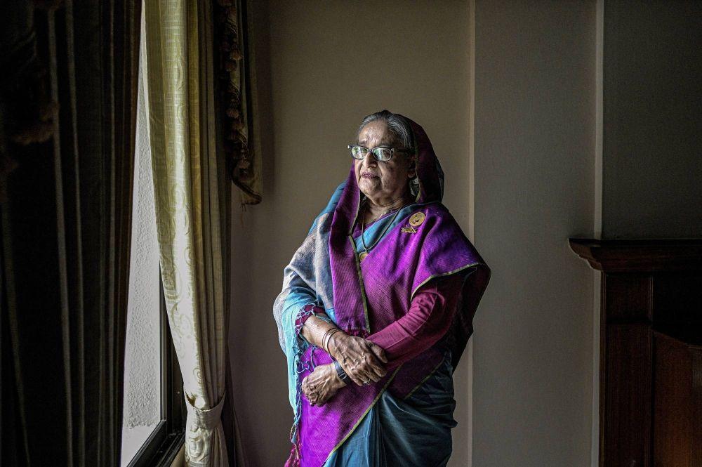 Sheikh Hasina standing by a window